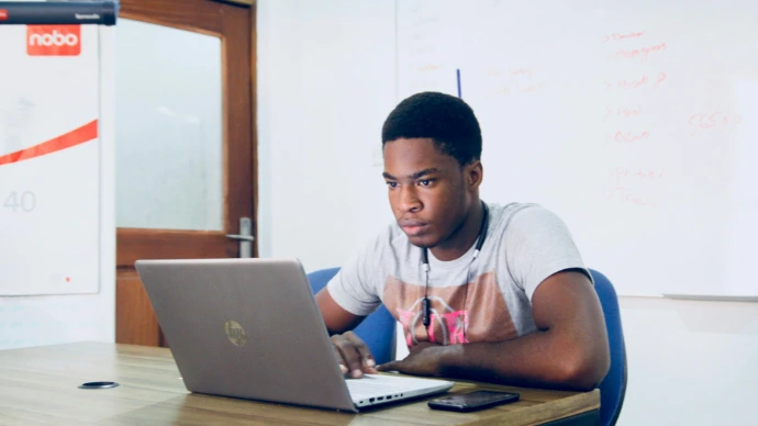 man in grey shirt using grey laptop computer
